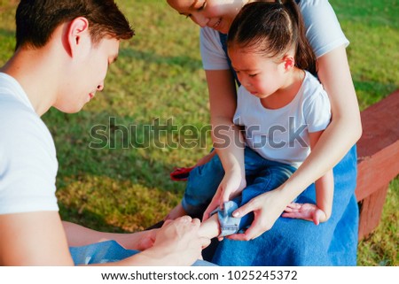 

Family take care small child girl naughty in playground until her have lesion on the feet Royalty-Free Stock Photo #1025245372
