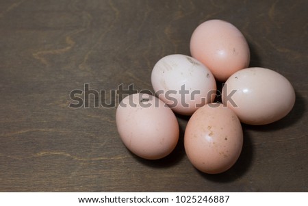 Fresh dirty natural organic chicken eggs. Farm eggs on wooden background.