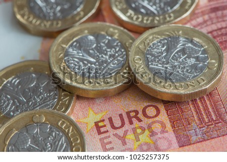 A close up view of British Pound coins on Euro banknote Royalty-Free Stock Photo #1025257375