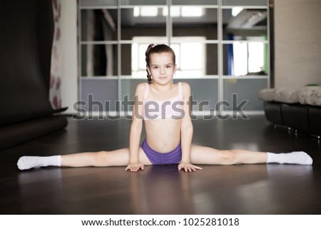 little caucasian girl sitting on a twine