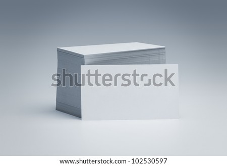 Stack of blank business cards over gray background with copy space