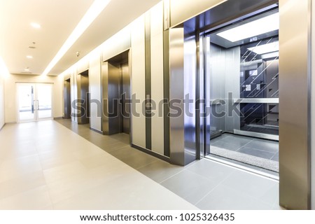 Modern steel elevator cabins in a business lobby or Hotel, Store, interior, office,perspective wide angle. Three elevators in hotel lobby. Royalty-Free Stock Photo #1025326435