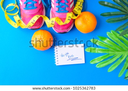 Sneakers with measuring tape on blue background. Sport shoes and sportive equipment for healthy shape.