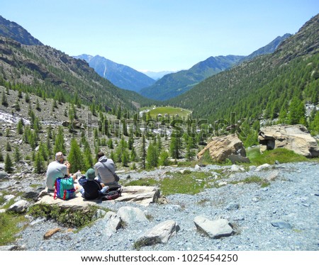 Wonderful view of a family with child having a good time and picnic in the mountain, on the Alps, Valle d'Aosta, Italy
