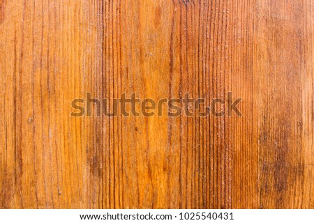The background of the wooden varnished surface with the patterns of wood fibers appearing through the lacquer. Red wood. Aged wooden background structure