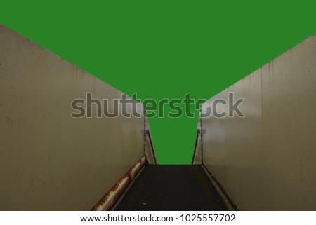 Green Screen above a walkway with low walls on either side and metal banisters at the end leading downwards.