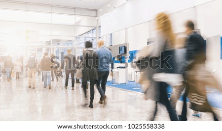 blurred people rushing at a trade fair hall