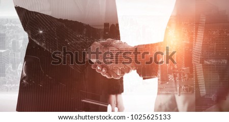 View of the city by night against composite image of business people shaking hands