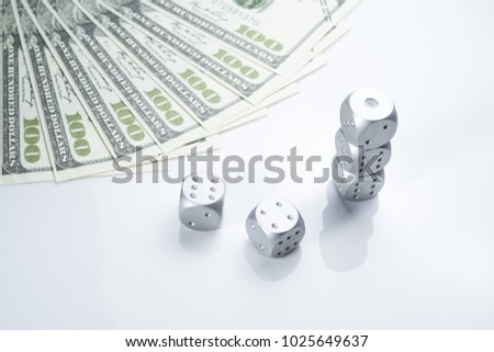 A conceptual Gambling image with Metal Dice and fake USD dollar notes on white isolated background