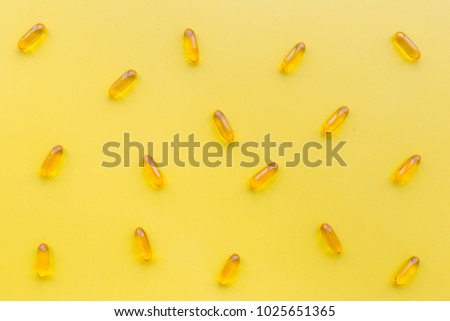 Color capsules. Medicine pills on yellow background top view pattern