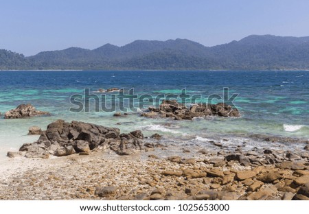 Rokroy island in Satun Thailand with the rocks on white sand and clear blue sea