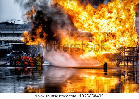 firefighter training., fireman using water and extinguisher to fighting with fire flame in an emergency situation., under danger situation all firemen wearing fire fighter suit for safety.