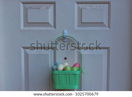 Basket full of Easter eggs hanging on a door