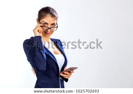 beautiful girl with a phone in a blue suit and glasses, business lady on a white background, office style