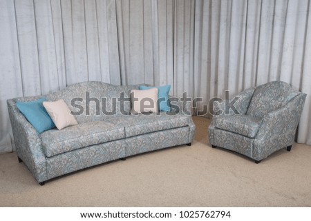 gray armchair against the wall with stripes