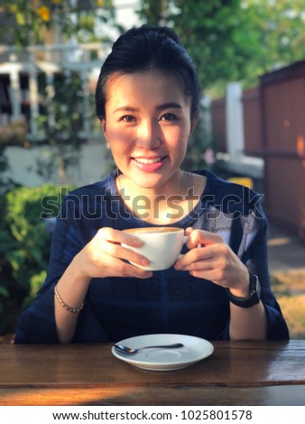 Young woman drinking coffee in in sunshine light enjoying her morning coffee.