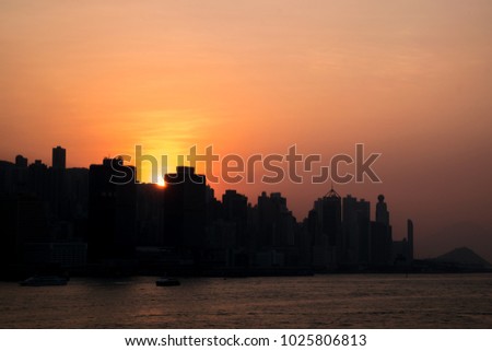The silhouette picture of Hong Kong city in the evening while the sun is setting down as a background.
