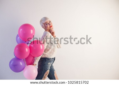 blonde girl with gifts and balloons for the birthday