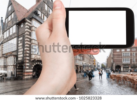 travel concept - tourist photographs Bremer Marktplatz (Bremen Market Square) in Germany in autumn rain on smartphone with cut out screen for advertising logo