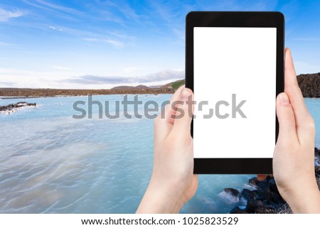 travel concept - tourist photographs Blue Lagoon Geothermal lake in Grindavik lava field outside spa resort in Iceland in autumn evening on tablet with cut out screen for advertising logo view of