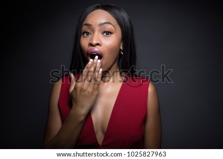 Black female model on a dark background with shocked and surprised expressions.