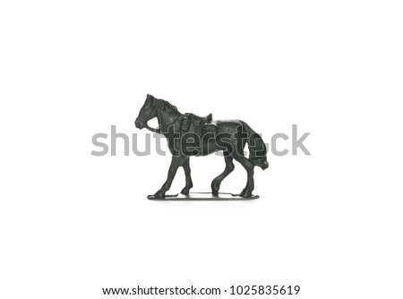 Green plastic miniature toy horse with saddle isolated on white background