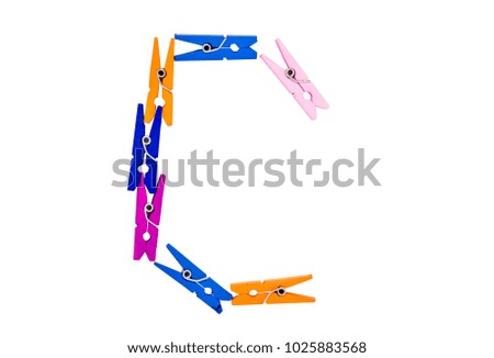 Alphabet font 'C' made from multi color plastic clothespin on white clear background.