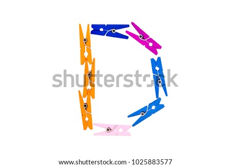 Alphabet font 'D' made from multi color plastic clothespin on white clear background.