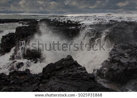 Powerful waves hit the cliff sprinkling water drops all over. Reykjanes peninsula, Iceland
