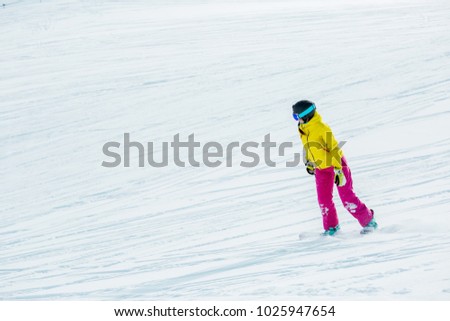 Image of athlete girl wearing helmet in sports clothes snowboarding