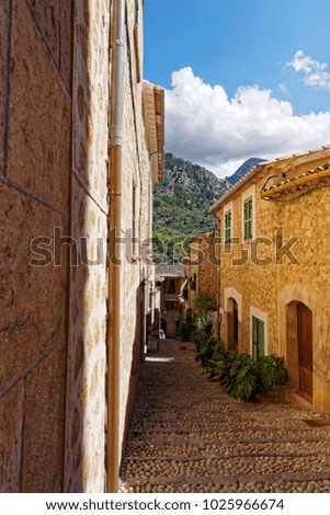narrow alley in spain on a sunny day with blue sky