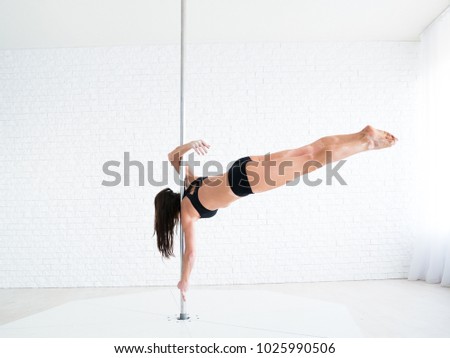 A beautiful young gymnast dancing. Poledance concept training