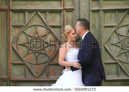 wedding couple posing in sun in front of old door