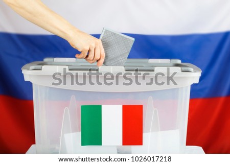 Italian citizen resident in Russia casts her ballot paper in a ballot box. Closeup