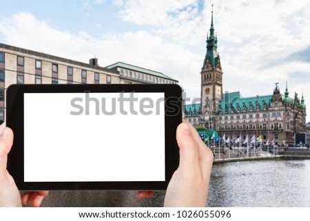 travel concept - tourist photographs quay of Binnenalster (Inner Alster Lake) and Hamburger Rathaus in Hamburg in autumn on tablet with cut out screen for advertising logo