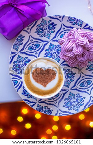 cappuccino heart in a white cup with a cupcake and cream
