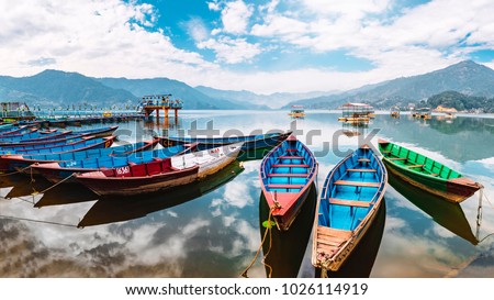 Colourful boats at shore of beautiful Phewa lake.  Pokhara, Nepal with Annapurna range in background. December 2017 Royalty-Free Stock Photo #1026114919