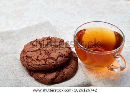 Top view close up picture of tea in transparent cup with biscuit cookies on a cotton napkin isolated on white background