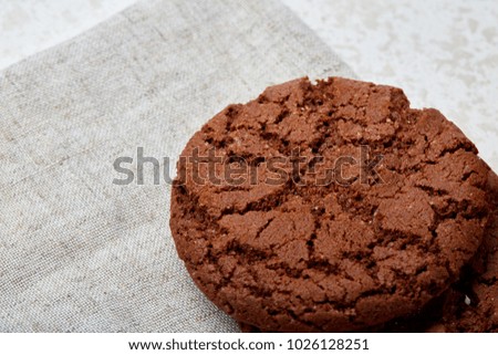 Closeup shallow depth of field picture of freshly baked chocolate chip cookies on burlap napkin.