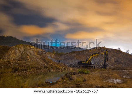 Excavator machine in construction site on night sky background