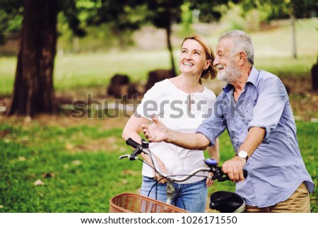 Portrait caucasian senior woman and old man, couple elder in love happy in park with bicycle Royalty-Free Stock Photo #1026171550