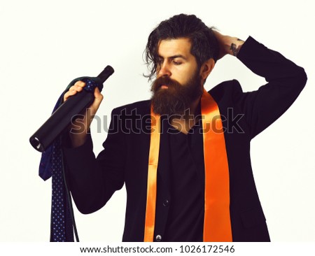 Bearded man, long beard. Brutal caucasian hipster with moustache in black suit with colorful ties on shoulders holding bottle isolated on white studio background