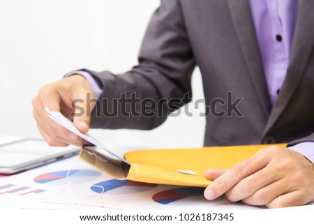 Businessmen are piling documents received from customers for analysis.
