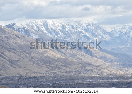 Mountain range with snow and city village below.