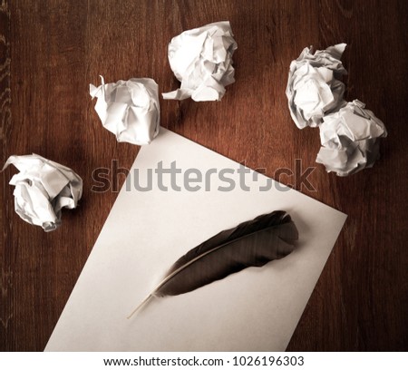 still life of paper and a crumpled paper on a table with a pen on a wooden table