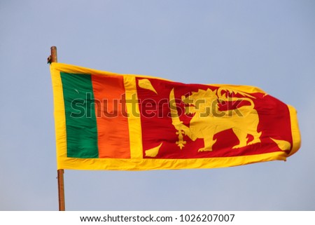 Sri Lanka flag (the Lion flag or Sinha flag) waving in the wind against a blue sky in the Galle Fort, Southern Province
