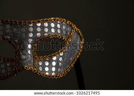 Mardi Gras mask with gold against a dark almost grey background