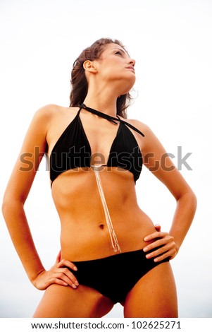 Gorgeous woman in a black bikini at the beach