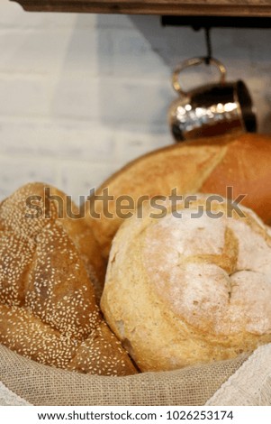 Assorted fresh loaves of bread sitting in a basket in the kitchen for dinner.