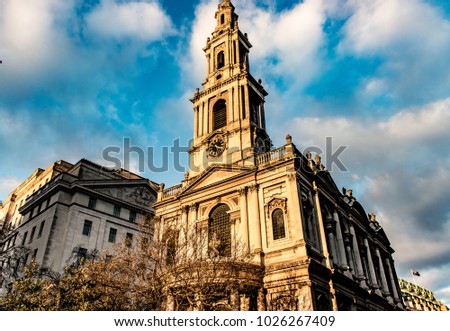 Strand, Central London, The sun is shining on a church on a cloudy day